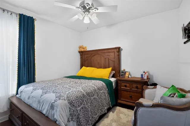 a bedroom with a bed and ceiling fan