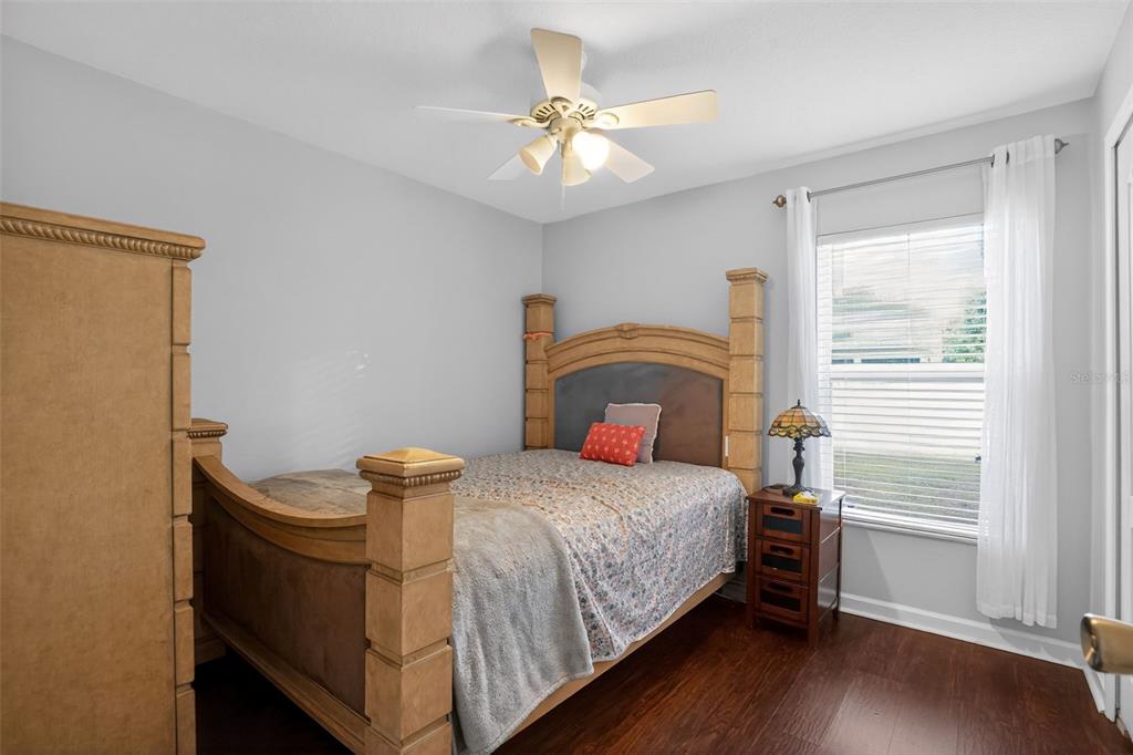 11519 Misty Isle Lane Riverview, FL 33579 - Photo 19 of 27 a bedroom with a bed and a chandelier