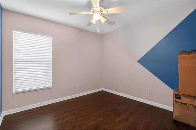 a view of a room with wooden floor and a ceiling fan