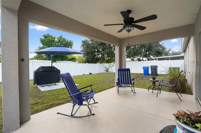 a view of a patio with a table chairs and a floor to ceiling window