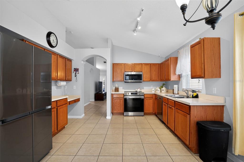 11519 Misty Isle Lane Riverview, FL 33579 - Photo 6 of 27 a large kitchen with stainless steel appliances granite countertop a stove top oven a sink dishwasher and a refrigerator