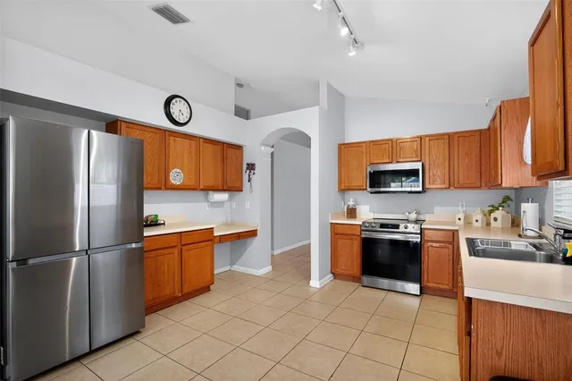 a kitchen with stainless steel appliances granite countertop a refrigerator stove top oven and sink