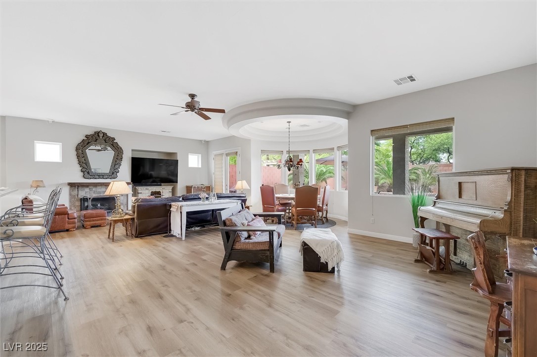 10720 Elm Ridge Avenue Las Vegas, NV 89144 - Photo 14 of 67 Living area with healthy amount of natural light, a fireplace, light wood-style floors, and a ceiling fan