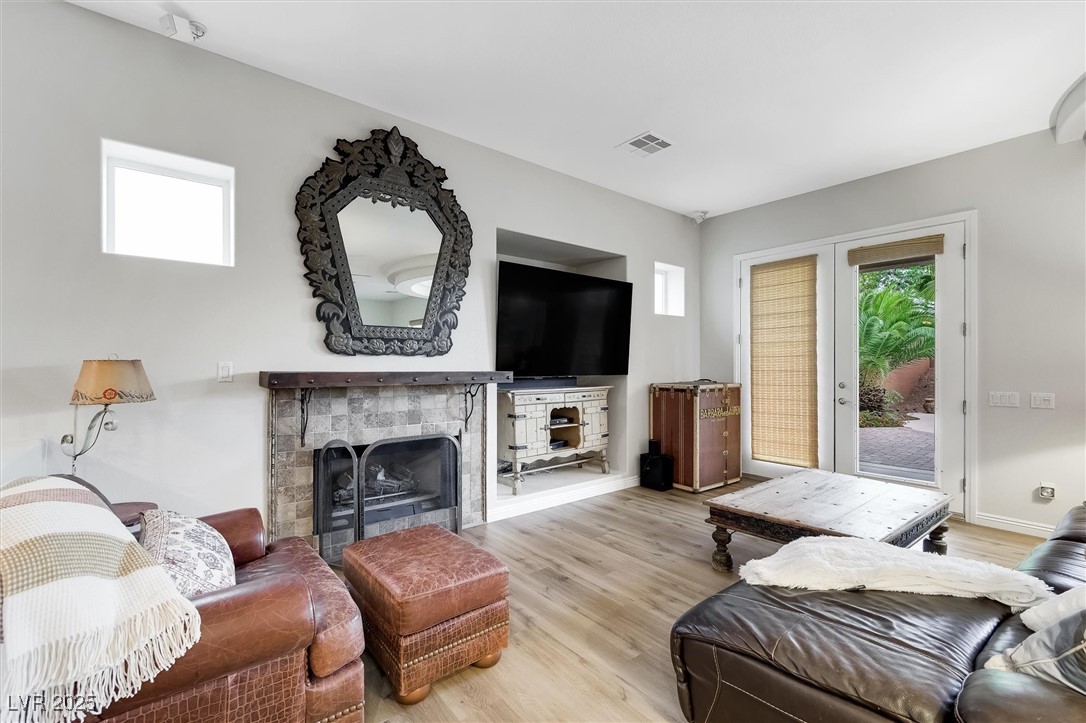 10720 Elm Ridge Avenue Las Vegas, NV 89144 - Photo 17 of 67 Living area featuring wood finished floors, a fireplace, and french doors