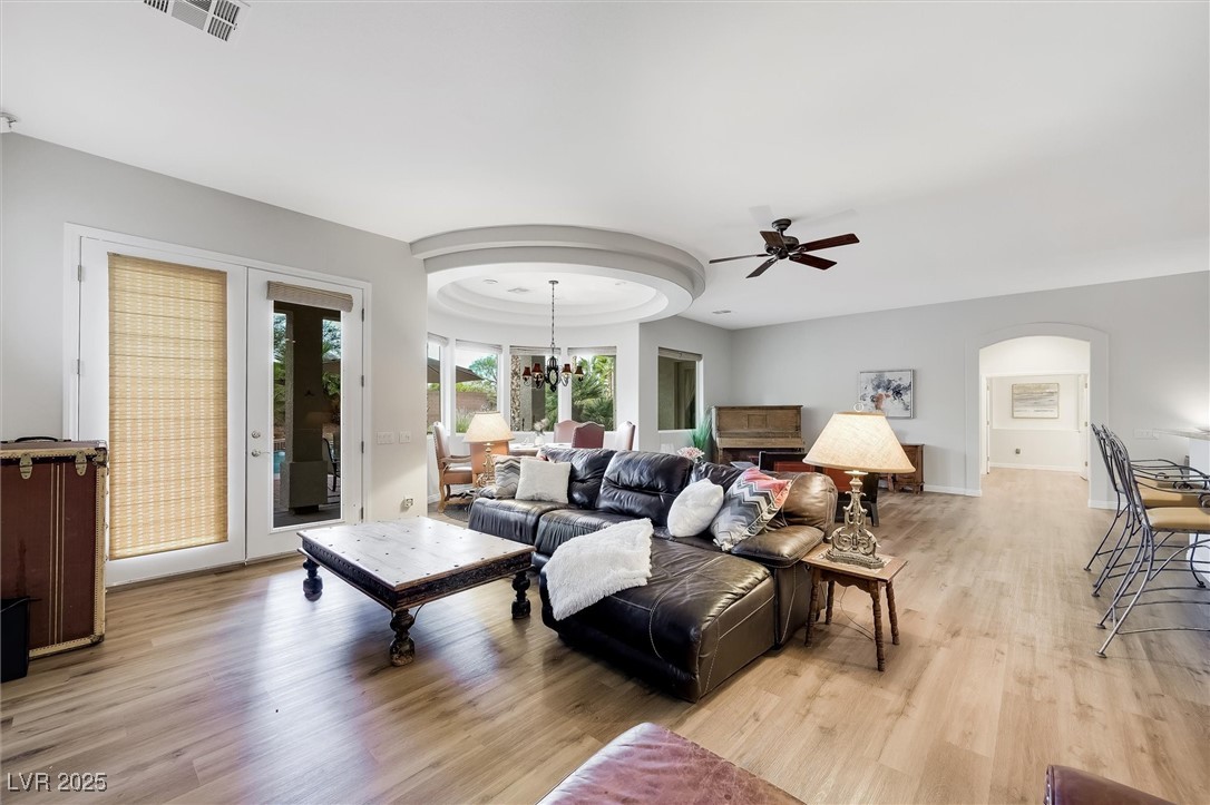 10720 Elm Ridge Avenue Las Vegas, NV 89144 - Photo 18 of 67 Living area featuring light wood-type flooring, arched walkways, ceiling fan, and a chandelier