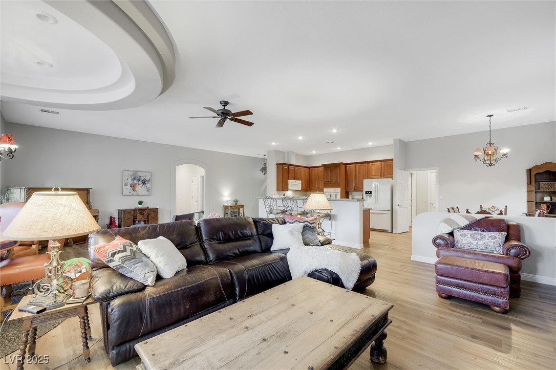 10720 Elm Ridge Avenue Las Vegas, NV 89144 - Photo 19 of 67 Living room with a chandelier, light wood-style floors, arched walkways, recessed lighting, and ceiling fan