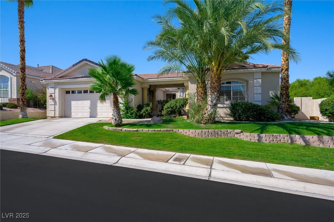 10720 Elm Ridge Avenue Las Vegas, NV 89144 - Photo 2 of 67 View of front of house with concrete driveway, stucco siding, a front lawn, a garage, and a tiled roof
