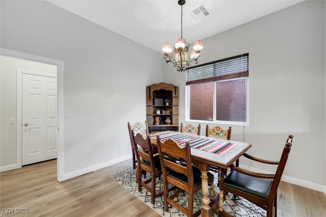 10720 Elm Ridge Avenue Las Vegas, NV 89144 - Photo 21 of 67 Dining room with light wood-style floors and a chandelier