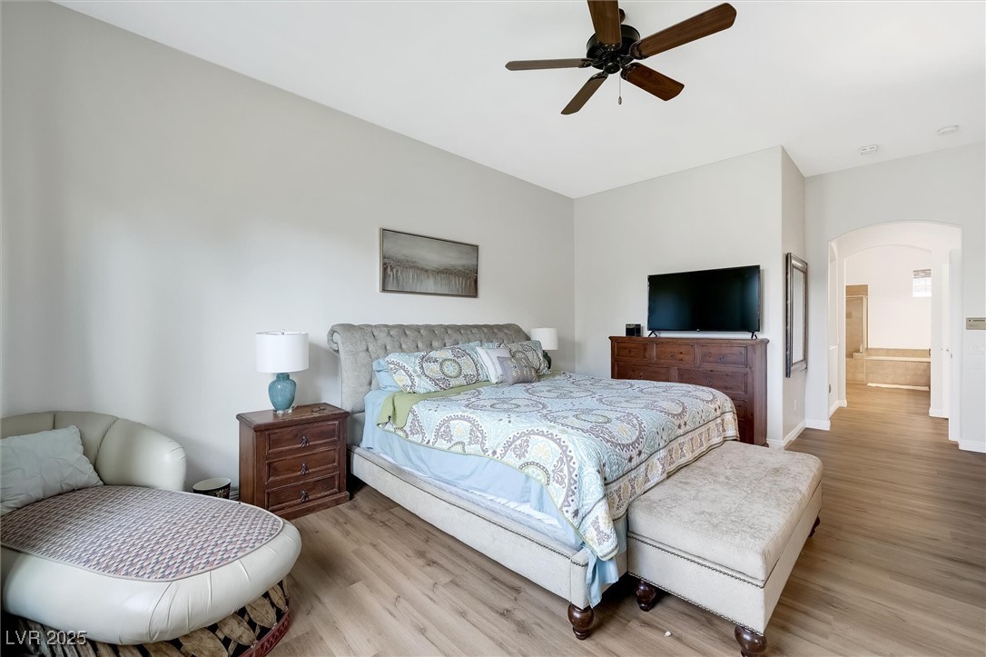 10720 Elm Ridge Avenue Las Vegas, NV 89144 - Photo 29 of 67 Bedroom with wood finished floors, ceiling fan, arched walkways, and ensuite bathroom