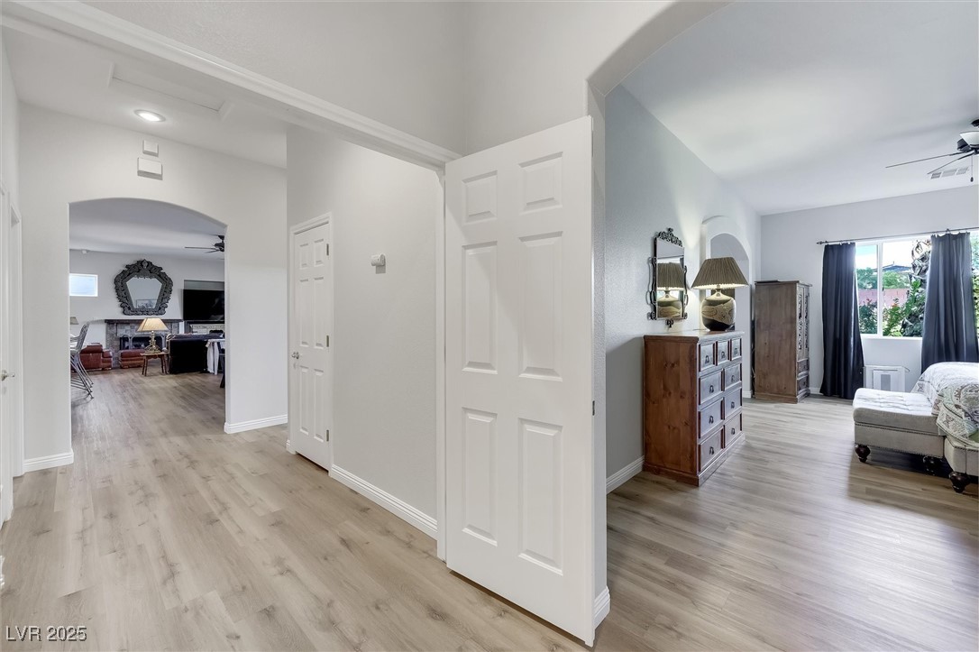 10720 Elm Ridge Avenue Las Vegas, NV 89144 - Photo 33 of 67 Hall featuring arched walkways, healthy amount of natural light, and light wood-style flooring