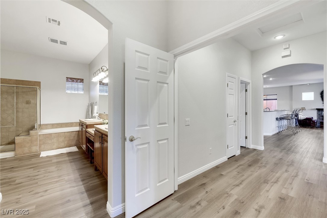 10720 Elm Ridge Avenue Las Vegas, NV 89144 - Photo 34 of 67 Hall featuring arched walkways and light wood-type flooring