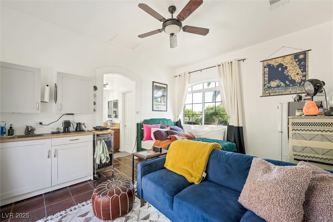10720 Elm Ridge Avenue Las Vegas, NV 89144 - Photo 43 of 67 Living area featuring arched walkways, dark tile patterned floors, and ceiling fan