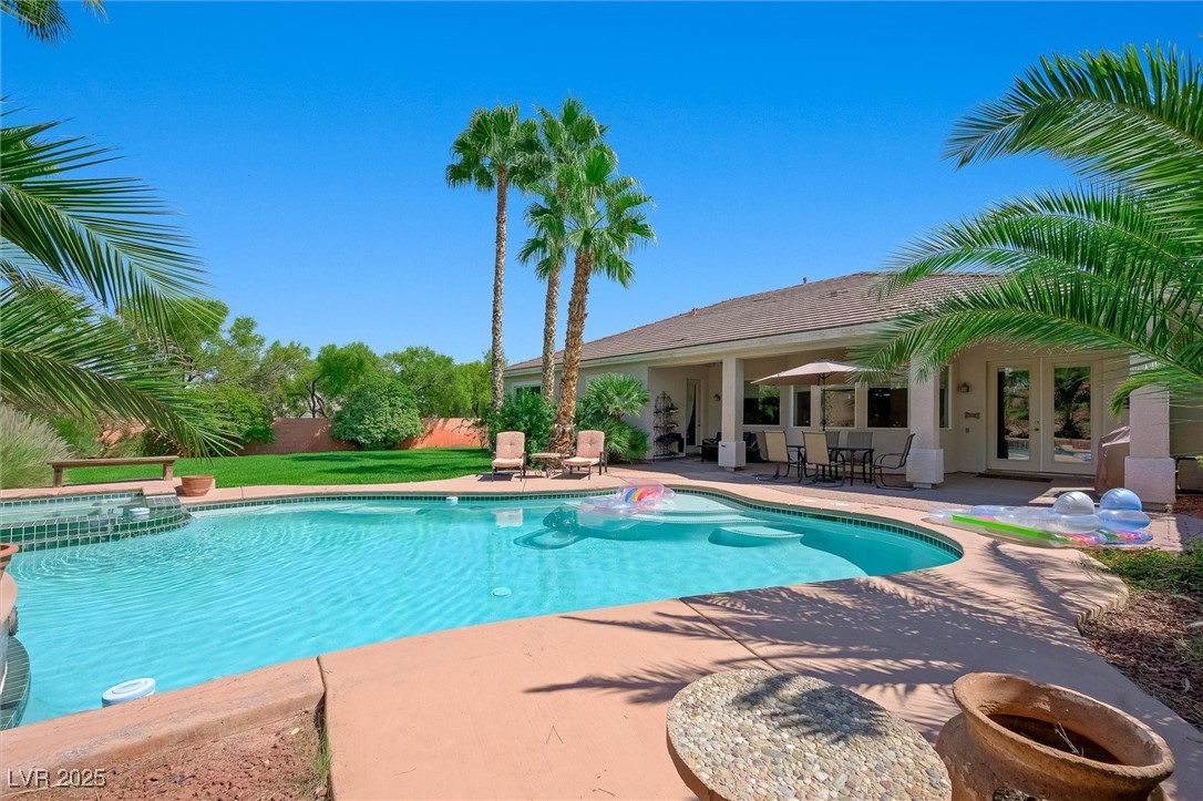 10720 Elm Ridge Avenue Las Vegas, NV 89144 - Photo 51 of 67 View of pool featuring french doors, a patio area, a pool with connected hot tub, and a lawn