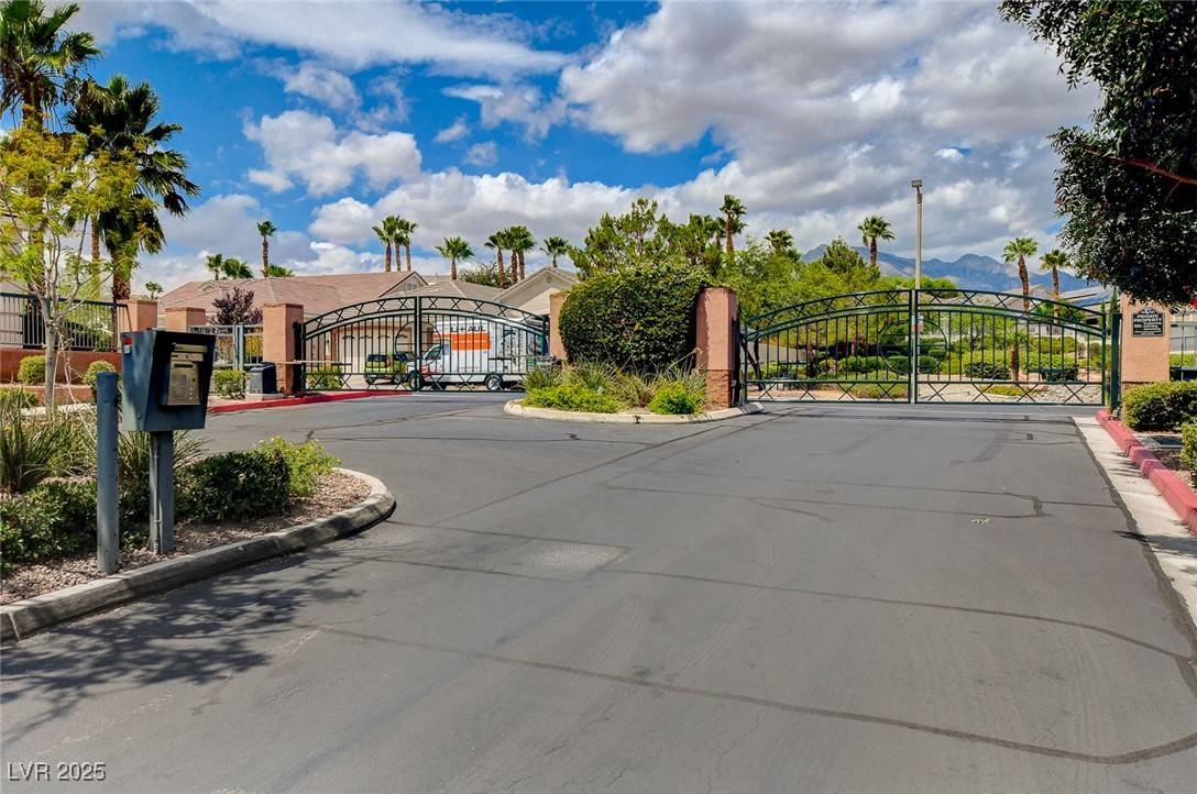 10720 Elm Ridge Avenue Las Vegas, NV 89144 - Photo 66 of 67 View of asphalt street featuring a gated entry, a gate, and curbs
