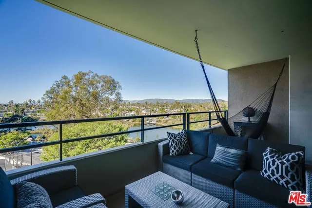 a living room with furniture potted plant and a large window