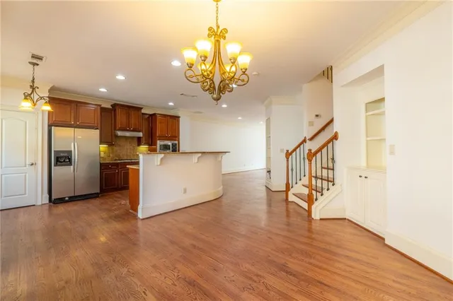 a view of a kitchen with a refrigerator and a wooden floor