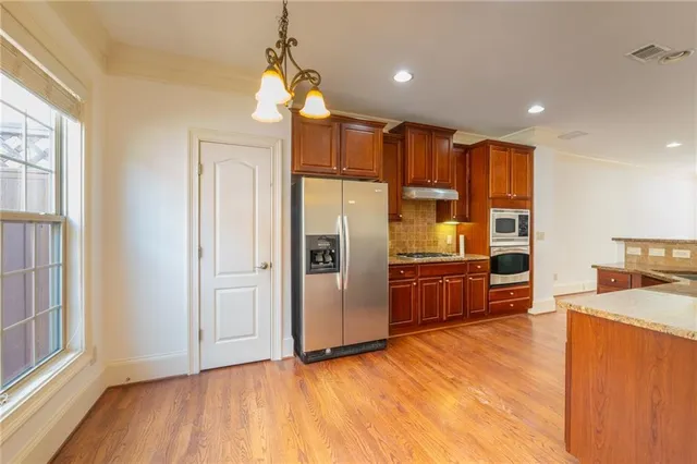 a kitchen with stainless steel appliances granite countertop a refrigerator a sink and a stove