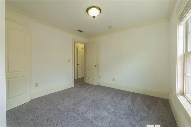 an empty room with cabinet and windows