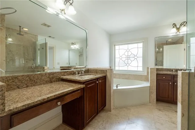 a bathroom with a granite countertop sink a toilet a bathtub and shower