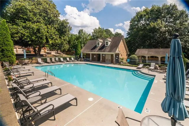 a view of a white house with a large windows and a road