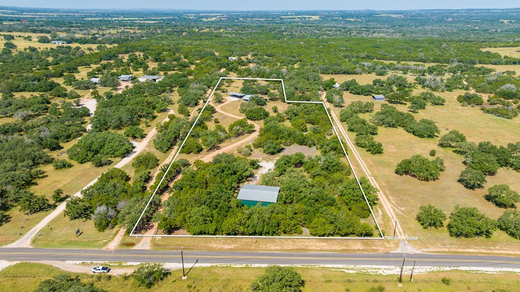 an aerial view of residential houses with outdoor space and trees