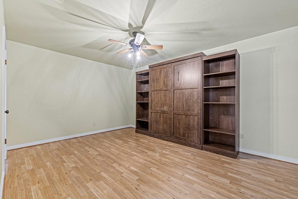 713 Ranch Road 1320 Hye, TX 78635 - Photo 13 of 26 an empty room with wooden floor closet and ceiling fan