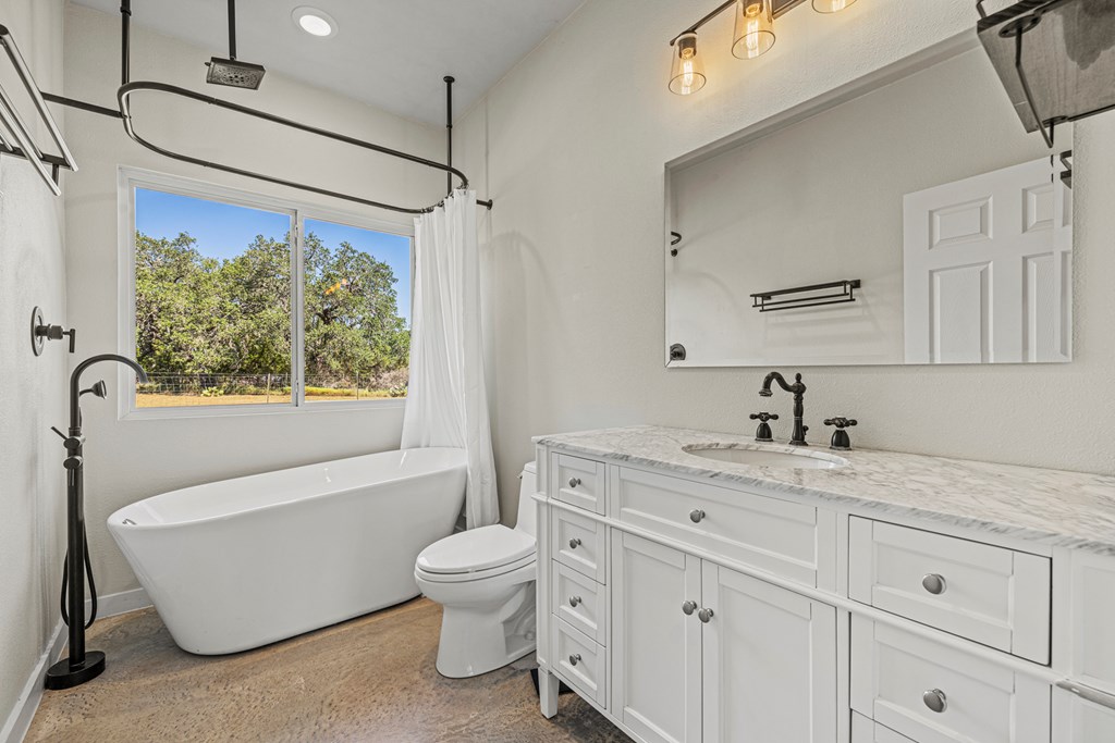 713 Ranch Road 1320 Hye, TX 78635 - Photo 15 of 26 a bathroom with a granite countertop sink toilet tub and mirror
