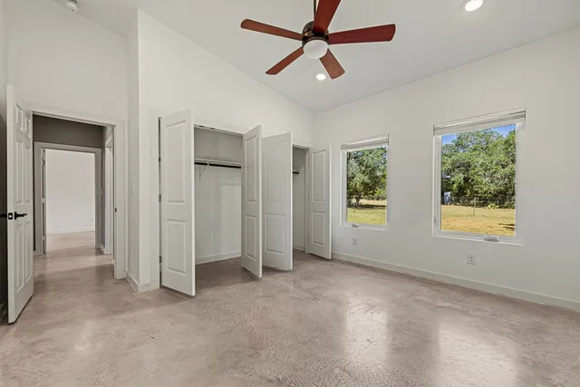 a view of empty room with window and ceiling fan
