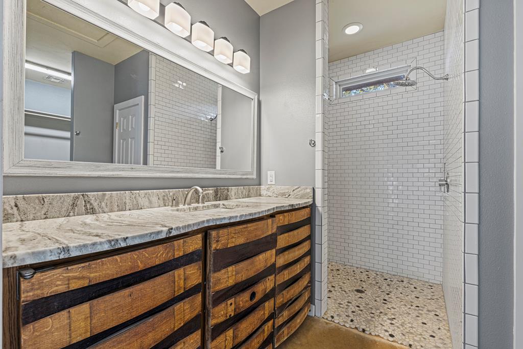 713 Ranch Road 1320 Hye, TX 78635 - Photo 21 of 26 a bathroom with a sink a mirror and shower