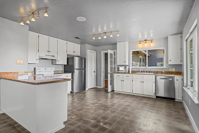 a kitchen with white cabinets and stainless steel appliances