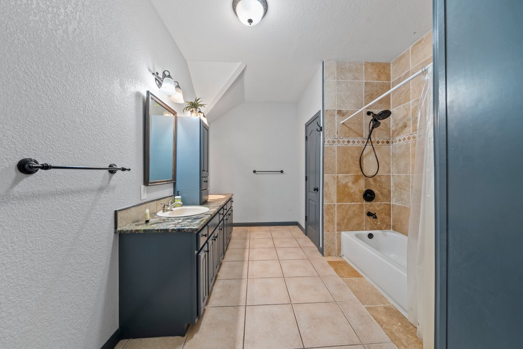 209 Lakeview Circle Spring Branch, TX 78070 - Photo 22 of 40 Bathroom featuring bathtub / shower combination, tile patterned flooring, a sink, baseboards, and double vanity