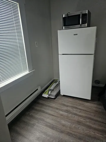 a view of a refrigerator in kitchen and a window