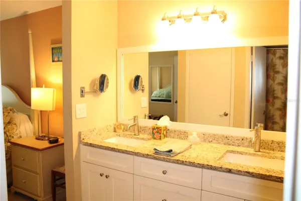 a bathroom with a granite countertop sink and a mirror