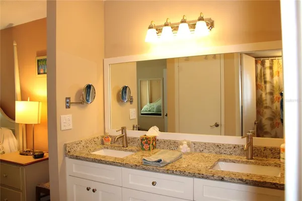 a bathroom with a granite countertop sink and a mirror