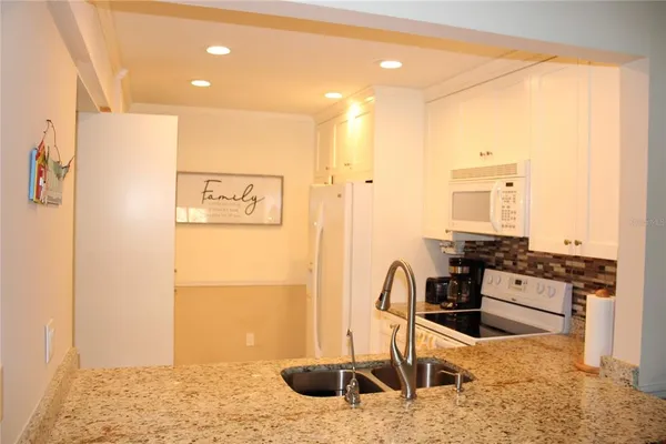 a kitchen with stainless steel appliances kitchen island granite countertop a refrigerator and stove