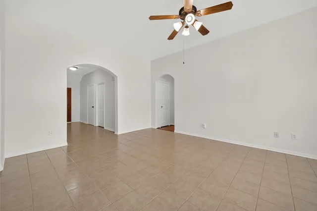 an empty room with chandelier fan