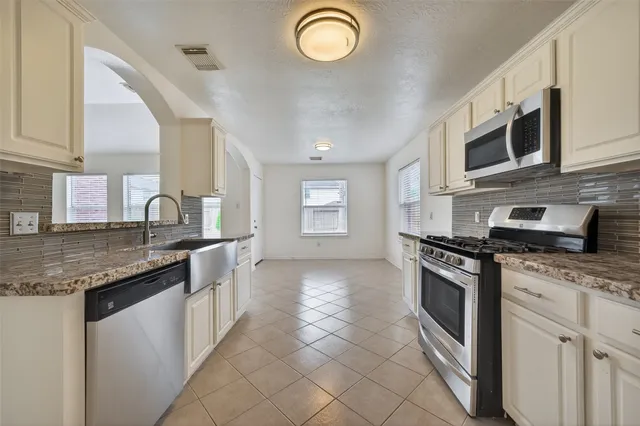 a kitchen with stainless steel appliances granite countertop a stove sink and cabinets