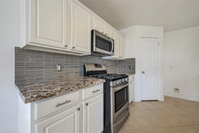 a kitchen with stainless steel appliances granite countertop a stove and a microwave
