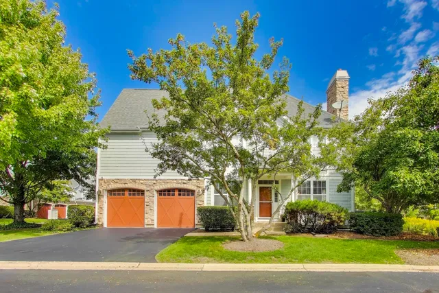 a front view of a house with a yard and a garage