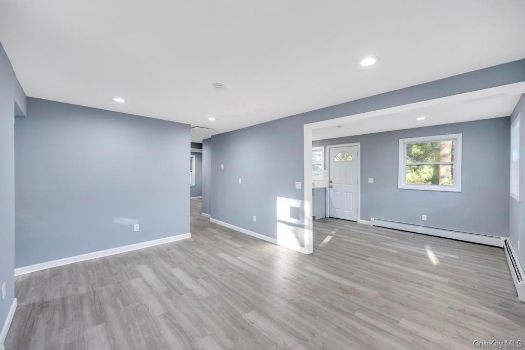 231 Elm Road West Mastic Beach, NY 11951 - Photo 16 of 34 a view of an empty room with wooden floor and a window