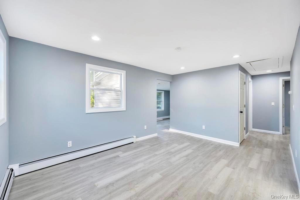 231 Elm Road West Mastic Beach, NY 11951 - Photo 18 of 34 an empty room with wooden floor and windows
