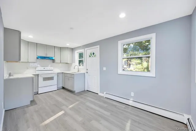 a kitchen with white cabinets and white appliances
