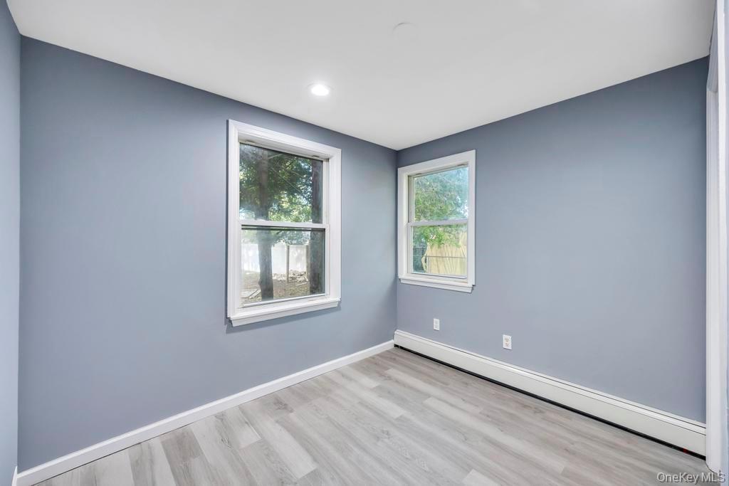 231 Elm Road West Mastic Beach, NY 11951 - Photo 27 of 34 an empty room with wooden floor and windows