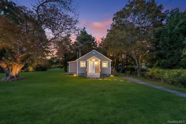 a front view of a house with a yard and trees