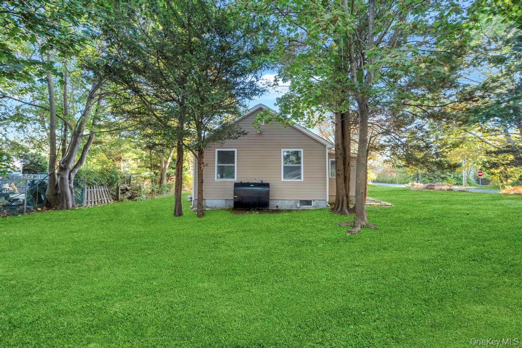 231 Elm Road West Mastic Beach, NY 11951 - Photo 9 of 34 a house with green field in front of it