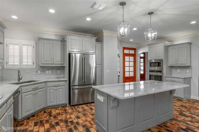 a kitchen with stainless steel appliances granite countertop a sink refrigerator and cabinets