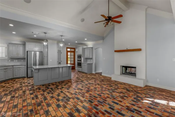 a large kitchen with white cabinets and a refrigerator