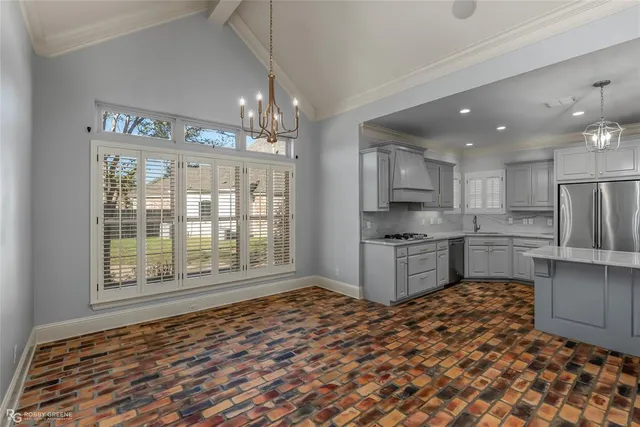 a kitchen with stainless steel appliances granite countertop a refrigerator and a stove top oven