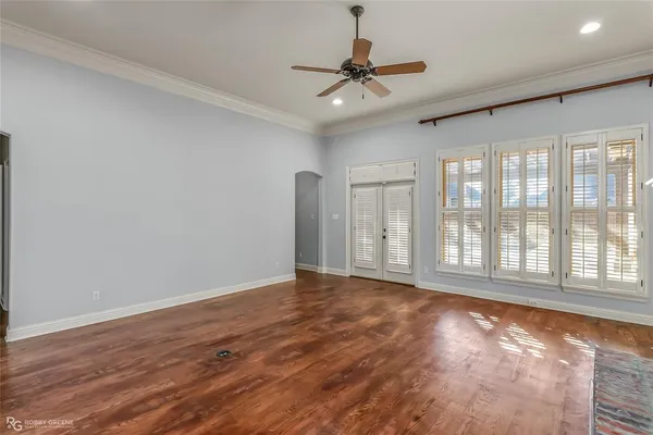 a view of an empty room with a window and wooden floor