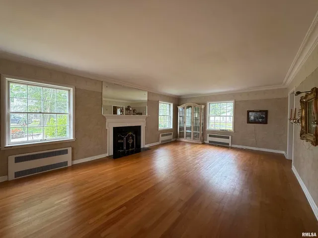an empty room with windows fireplace and windows